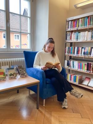 Stadtbücherei Ausleihangebot Eine Frau liest ein Buch in der Stadtbücherei