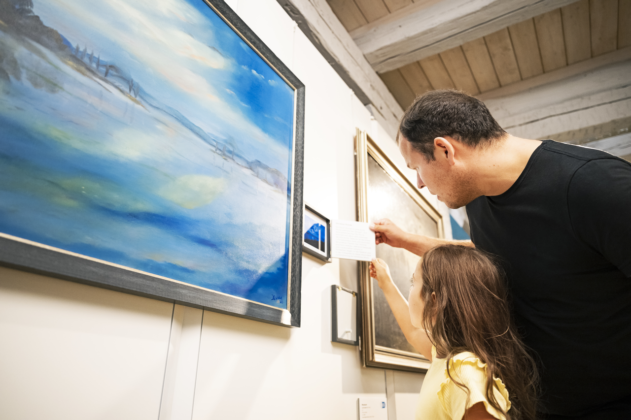 Foto: Ilia Mess Ein Vater und seine Tochter betrachten ein Bild in der Ausstellung