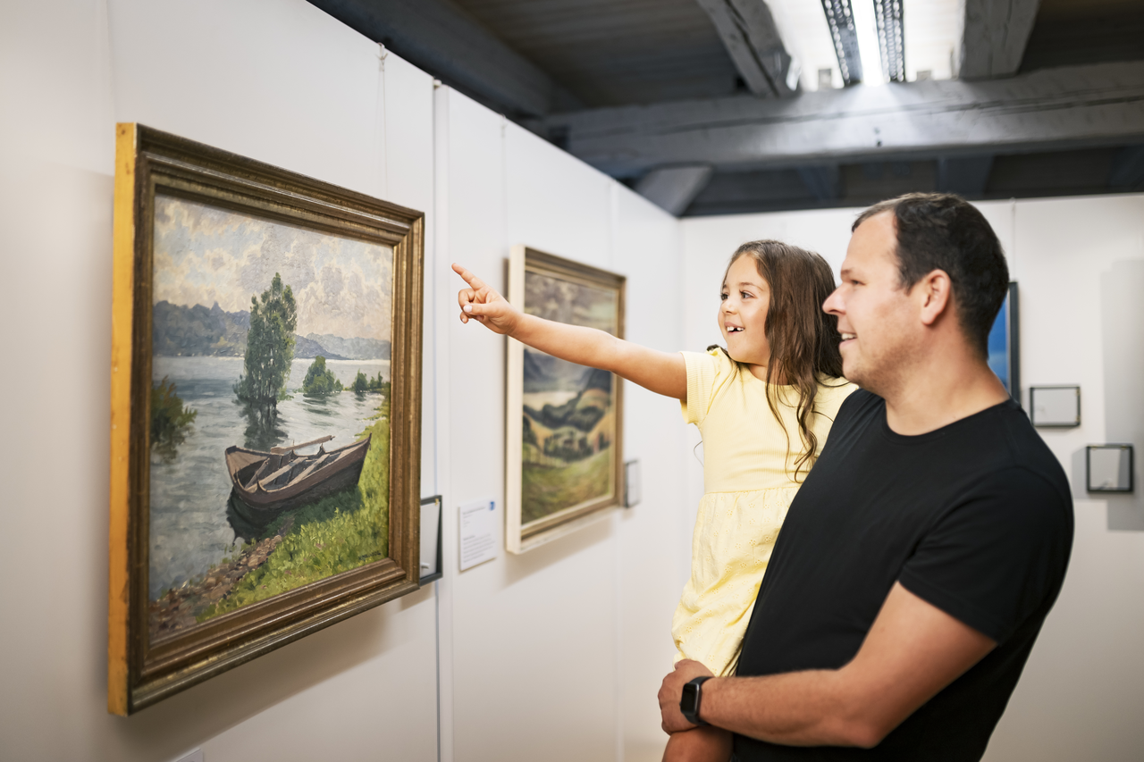 Ein Vater und seine Tochter betrachten ein Bild in der Ausstellung
